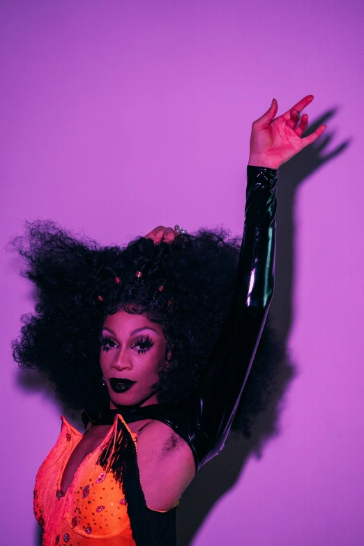 a woman standing in front of a purple wall, an album cover, drag queen, alexis franklin, dark. no text, wavy hair spread out