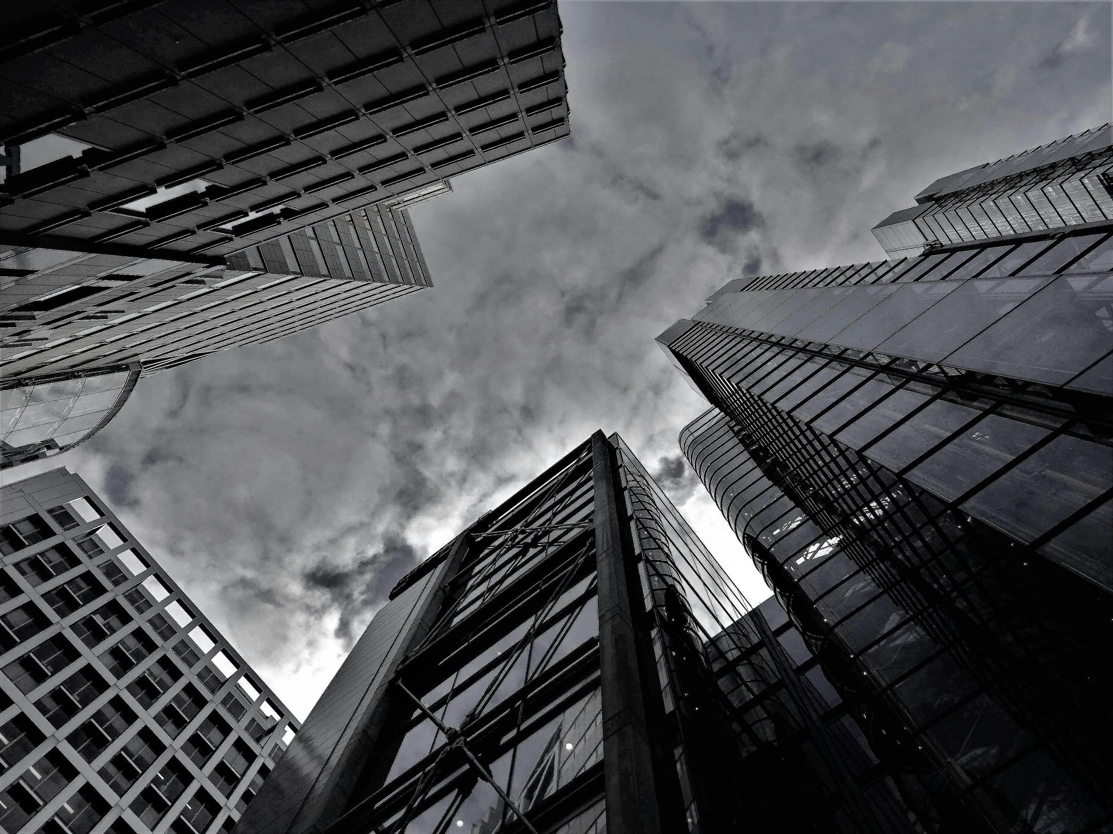 a black and white photo of tall buildings, by Adam Rex, pexels contest winner, . dramatic angle, centralised, ilustration, video