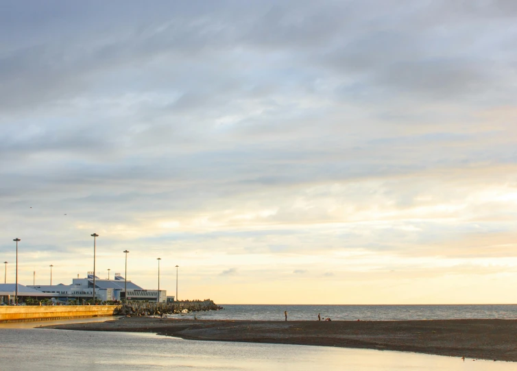 a man flying a kite on top of a sandy beach, inspired by Edwin Georgi, pexels contest winner, minimalism, harbour, caulfield, panoramic shot, late summer evening