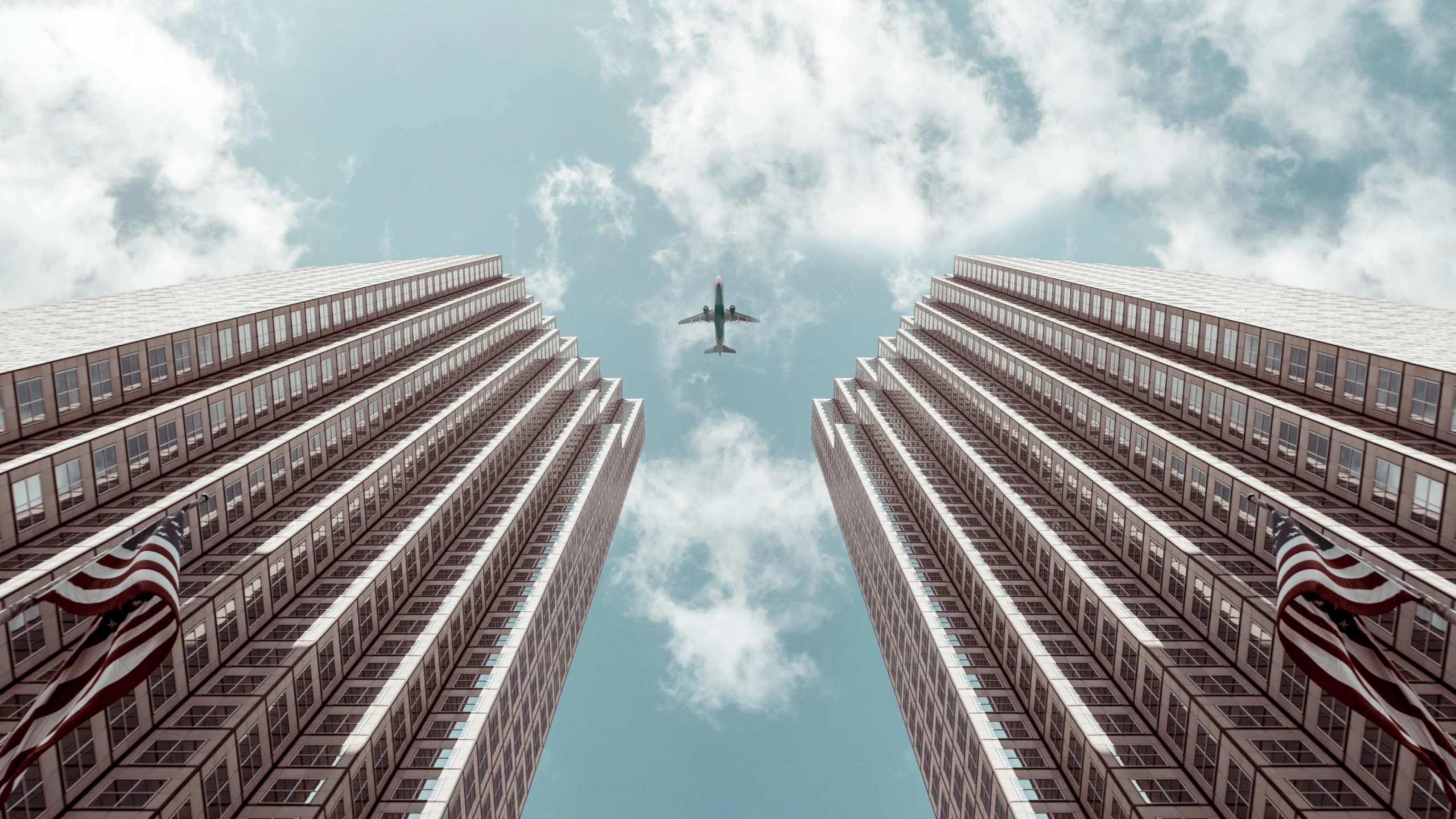 a plane is flying over some tall buildings, inspired by Beeple, pexels contest winner, symmetrical image, clear skies, viewed from the ground, tall metal towers