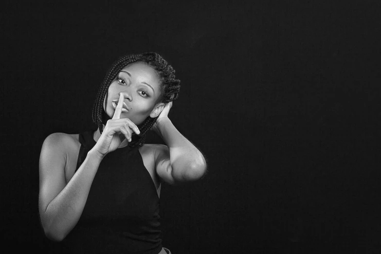 a black and white photo of a woman making a hush sign, inspired by Carrie Mae Weems, pexels, conceptual art, black young woman, set photo, cute woman, photo pinterest