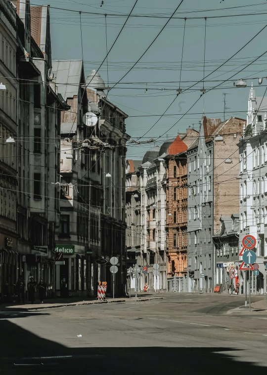 a city street filled with lots of tall buildings, a photo, pexels contest winner, viennese actionism, in empty!!!! legnica, wires hanging down everywhere, slide show, 4 k cinematic photo