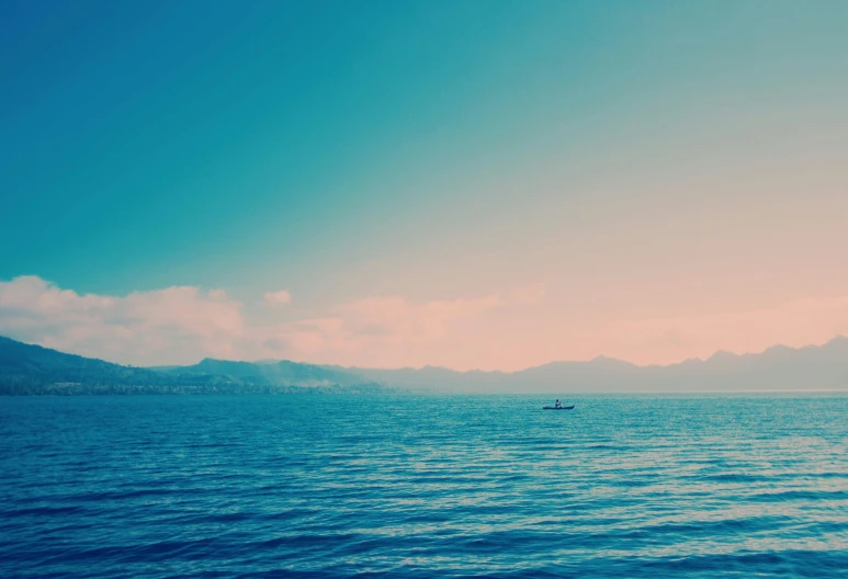 a large body of water with mountains in the background, a picture, unsplash, romanticism, blue sea, one small boat, sunfaded, hd footage