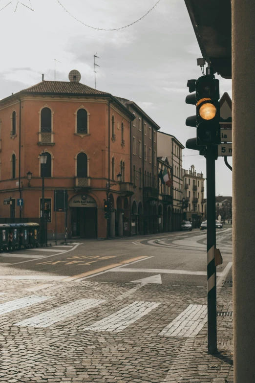 a traffic light sitting on the side of a road, a picture, by Alessandro Allori, pexels contest winner, renaissance, in the foreground a small town, street corner, calm afternoon, round buildings in background