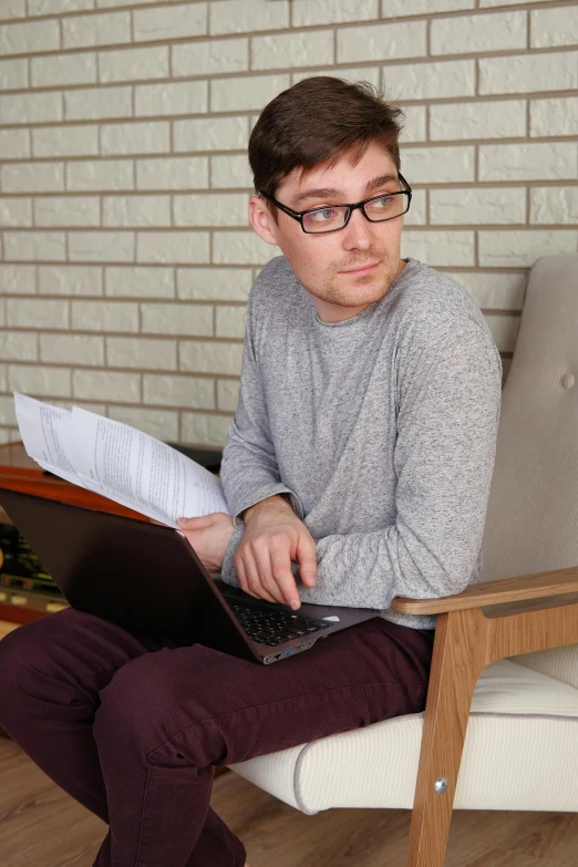 a man sitting in a chair with a laptop, trending on reddit, photorealism, non binary model, reading glasses, high-quality photo, 2 3 years old