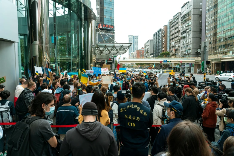 a group of people that are standing in the street, yellow and blue and cyan, in hong kong, concerned, center of image