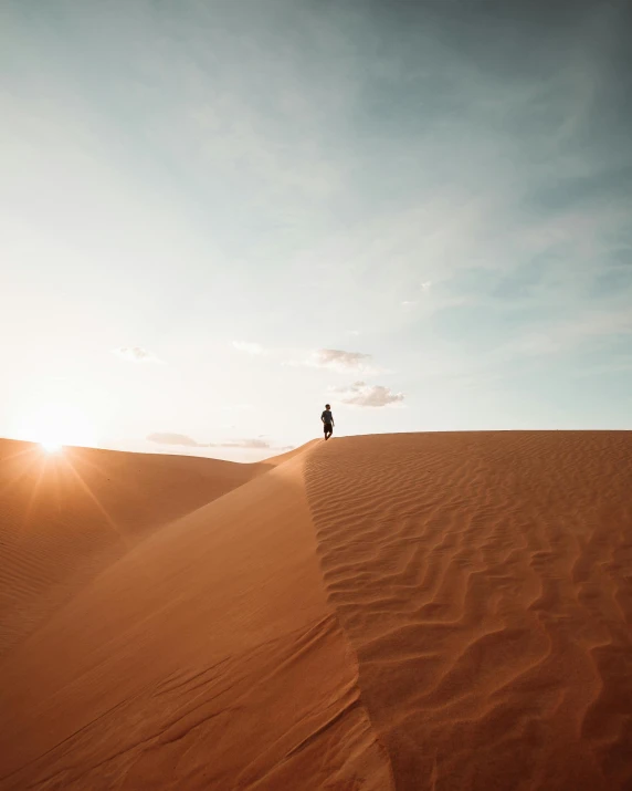 a person standing on top of a sand dune, trending on vsco, multiple stories, mars vacation photo