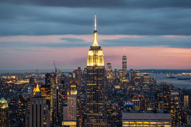 the empire state building lit up at night, a picture, unsplash contest winner, renaissance, dusk light, 8k hd resolution”