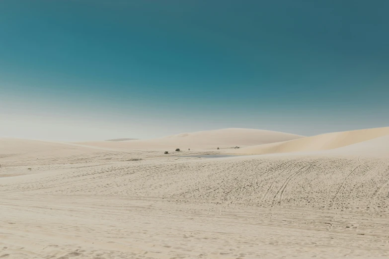 a man riding a snowboard down a snow covered slope, a picture, unsplash contest winner, minimalism, in the australian desert, people in beach, landscape of flat wastelands, sand storm