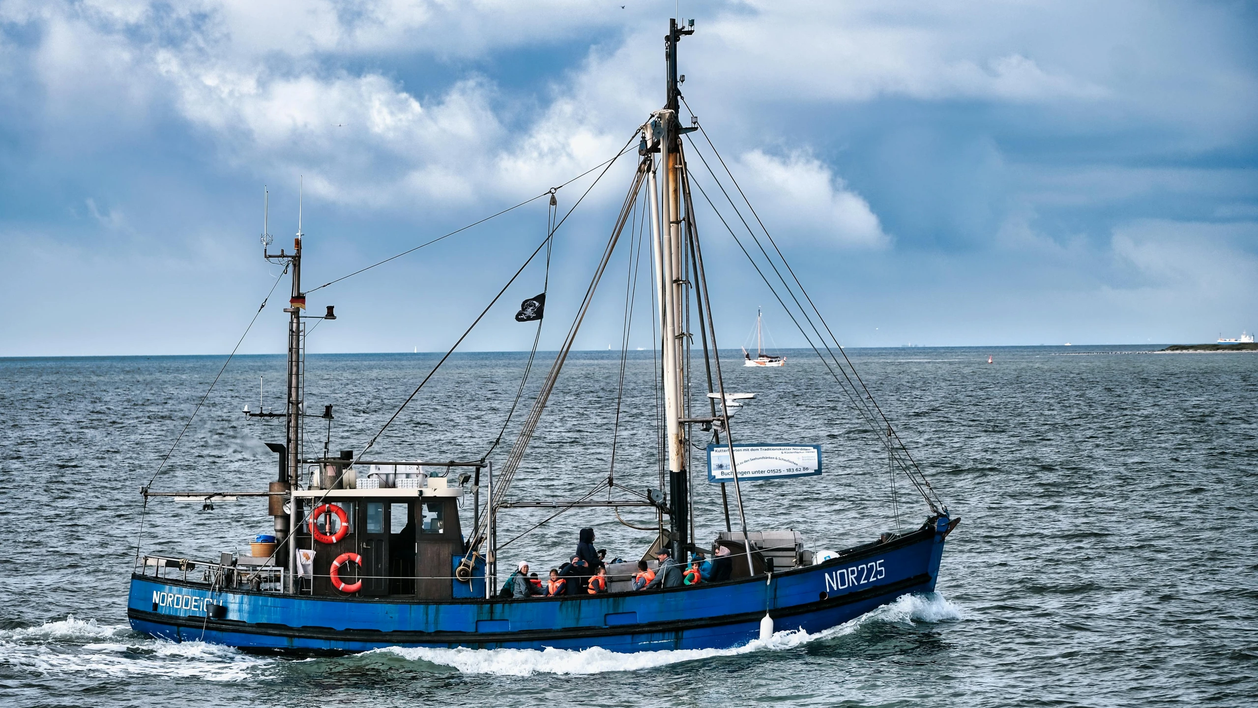 a blue boat traveling across a large body of water, by Niels Lergaard, pexels contest winner, fishing boat, mary anning, customers, three masts