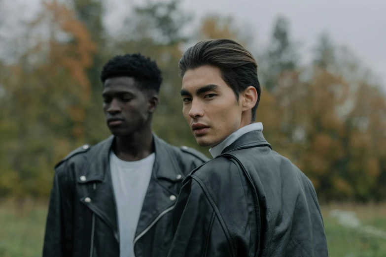 two men standing next to each other in a field, trending on pexels, realism, she wears leather jacket, ethnicity : japanese, fashion model features, ash thorp khyzyl saleem