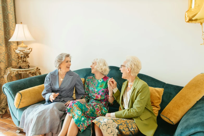 a group of women sitting on top of a green couch, by Emma Andijewska, pexels, elderly, 3 - piece, fully dressed, smiling at each other