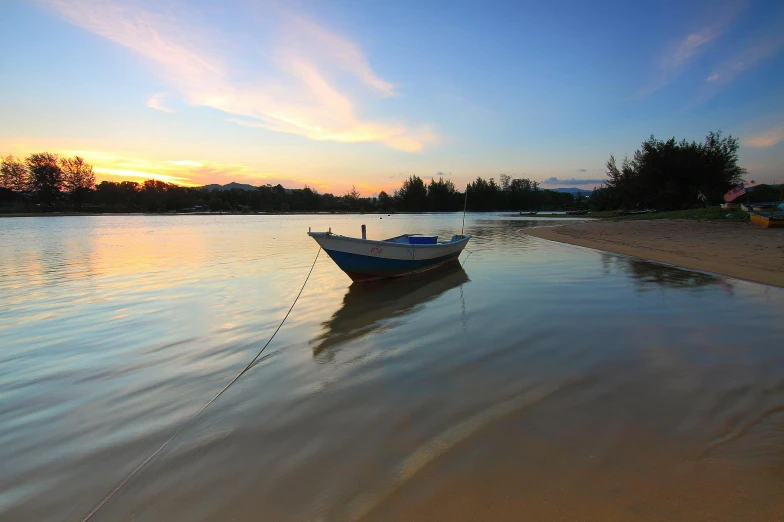 a boat sitting on top of a beach next to a body of water, hurufiyya, at dawn, phuoc quan, shallow water, body of water