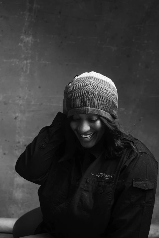 a black and white photo of a woman sitting on a bench, by Andrew Domachowski, knitted hat, sza, smiling spartan, studio lit