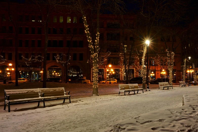 a couple of benches sitting on top of a snow covered ground, by Washington Allston, unsplash contest winner, christmas lights, town square, calm evening, washington main street