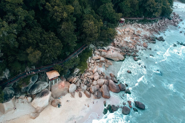 a group of people standing on top of a beach next to the ocean, by Lee Loughridge, pexels contest winner, graffiti, malaysia jungle, “ aerial view of a mountain, boulders, beachfront mansion