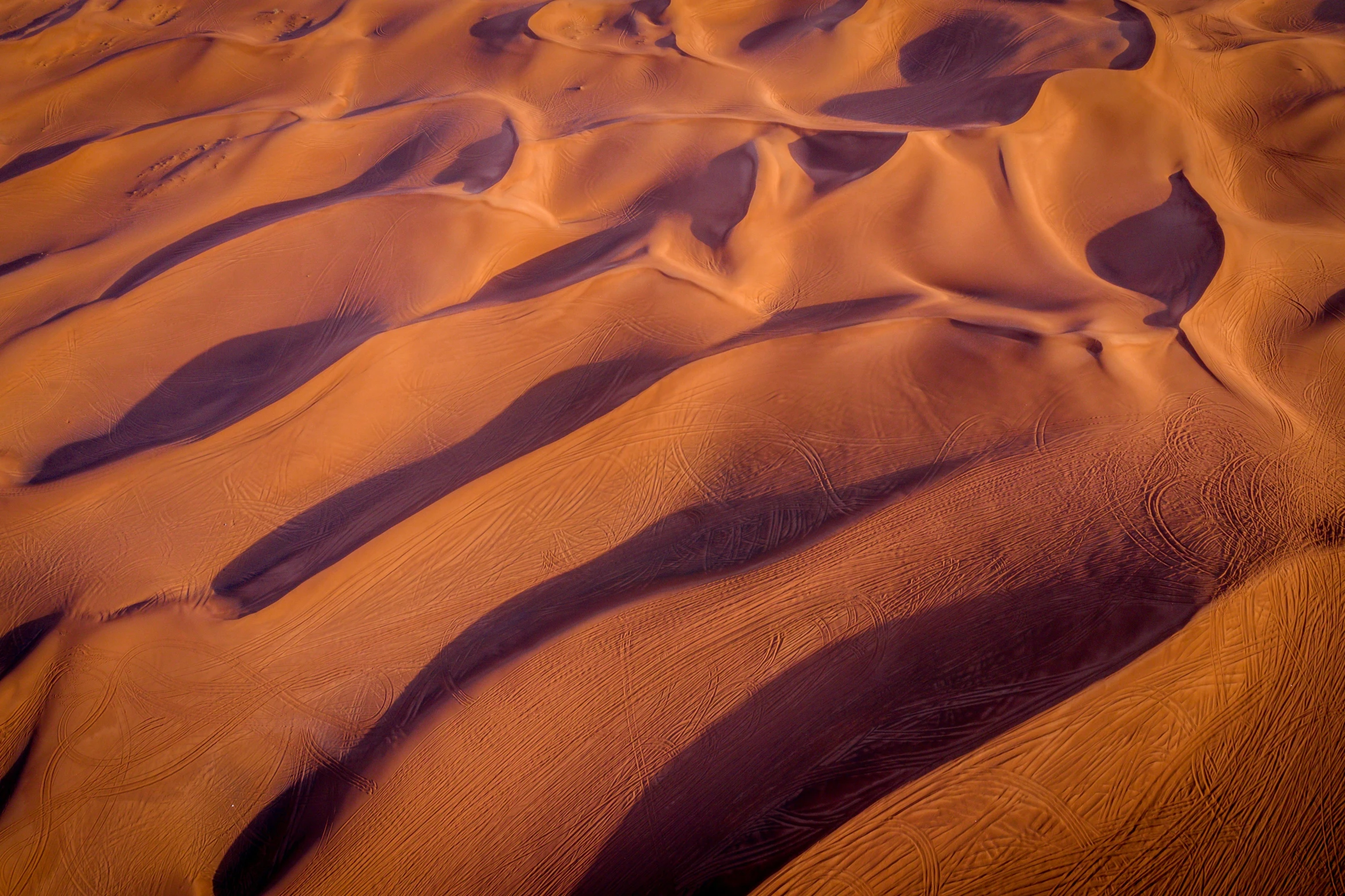 a group of people standing on top of a desert, by Peter Churcher, pexels contest winner, land art, ripples, taken from a plane, warm hues, late afternoon