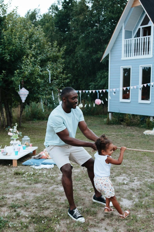 a man and a little girl playing a game of frisbee, pexels contest winner, midsommar style, black man, with axe, at a birthday party