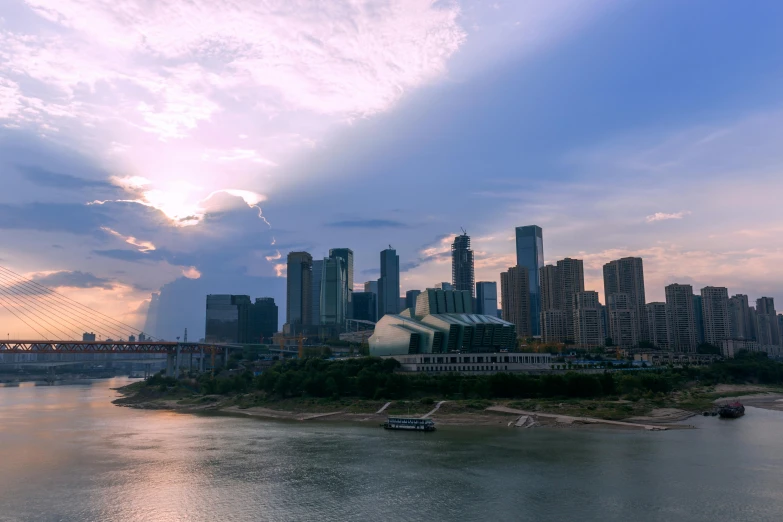 a large body of water with a city in the background, by Zha Shibiao, pexels contest winner, yeg, dramatic afternoon lighting, minn, building along a river