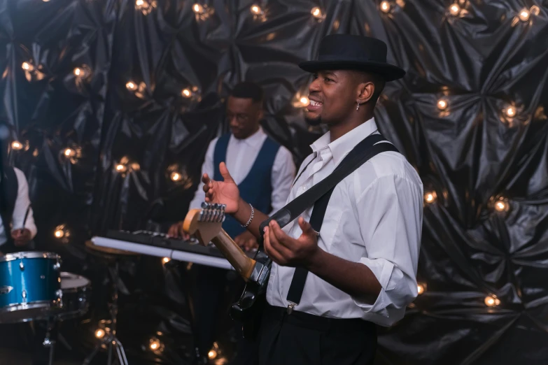 a group of men standing next to each other playing musical instruments, by Matt Cavotta, pexels, private press, ( ( dark skin ) ), geometric backdrop; led, wedding, 5 feet away