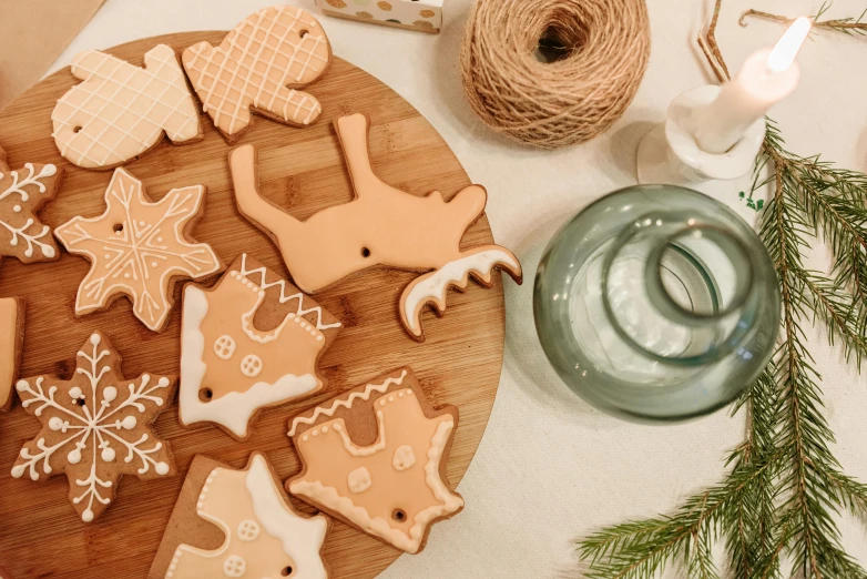 a wooden cutting board topped with christmas cookies, by Emma Andijewska, trending on pexels, folk art, cafe for felted animals, fish made of pancake, ivory and copper, organic ornament