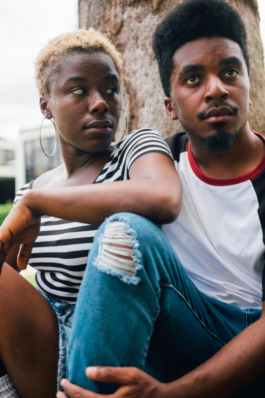 a man and a woman sitting next to each other, trending on unsplash, black arts movement, teenagers, looking threatening, summertime, loosely cropped