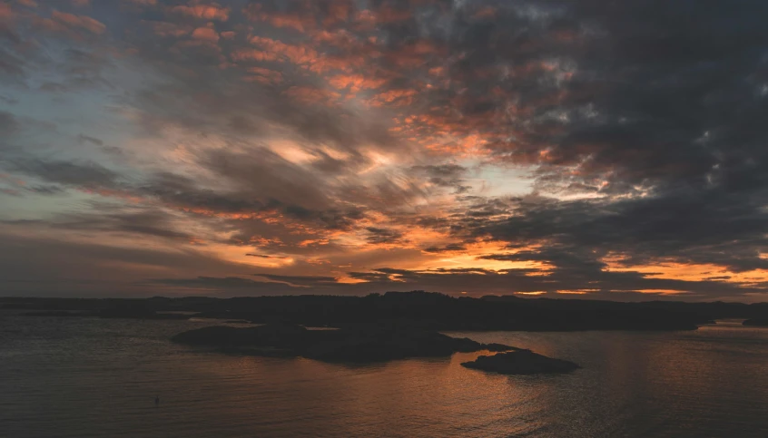 a large body of water under a cloudy sky, by Jesper Knudsen, pexels contest winner, happening, sunset panorama, aerial footage, archipelago, manly