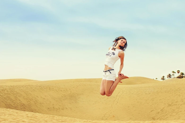 a woman jumping in the air in the desert, by Julia Pishtar, highest quality, 9 9 designs, professionally post-processed, raphael lecoste