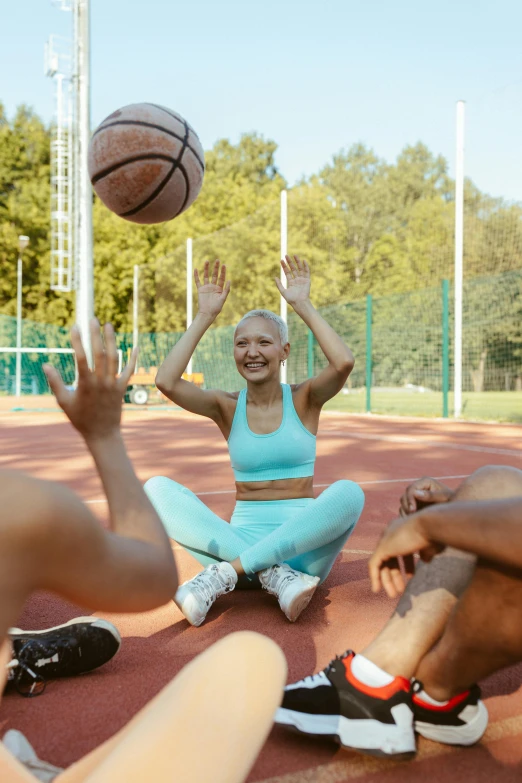 a group of people sitting on top of a basketball court, trending on dribble, short blue haired woman, bald, outside on the ground, excited