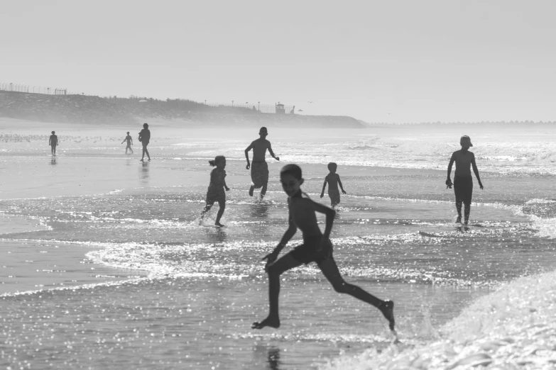 a group of people playing soccer on a beach, a black and white photo, by Nadir Afonso, pexels contest winner, people running, children playing at the beach, summer morning, hd footage