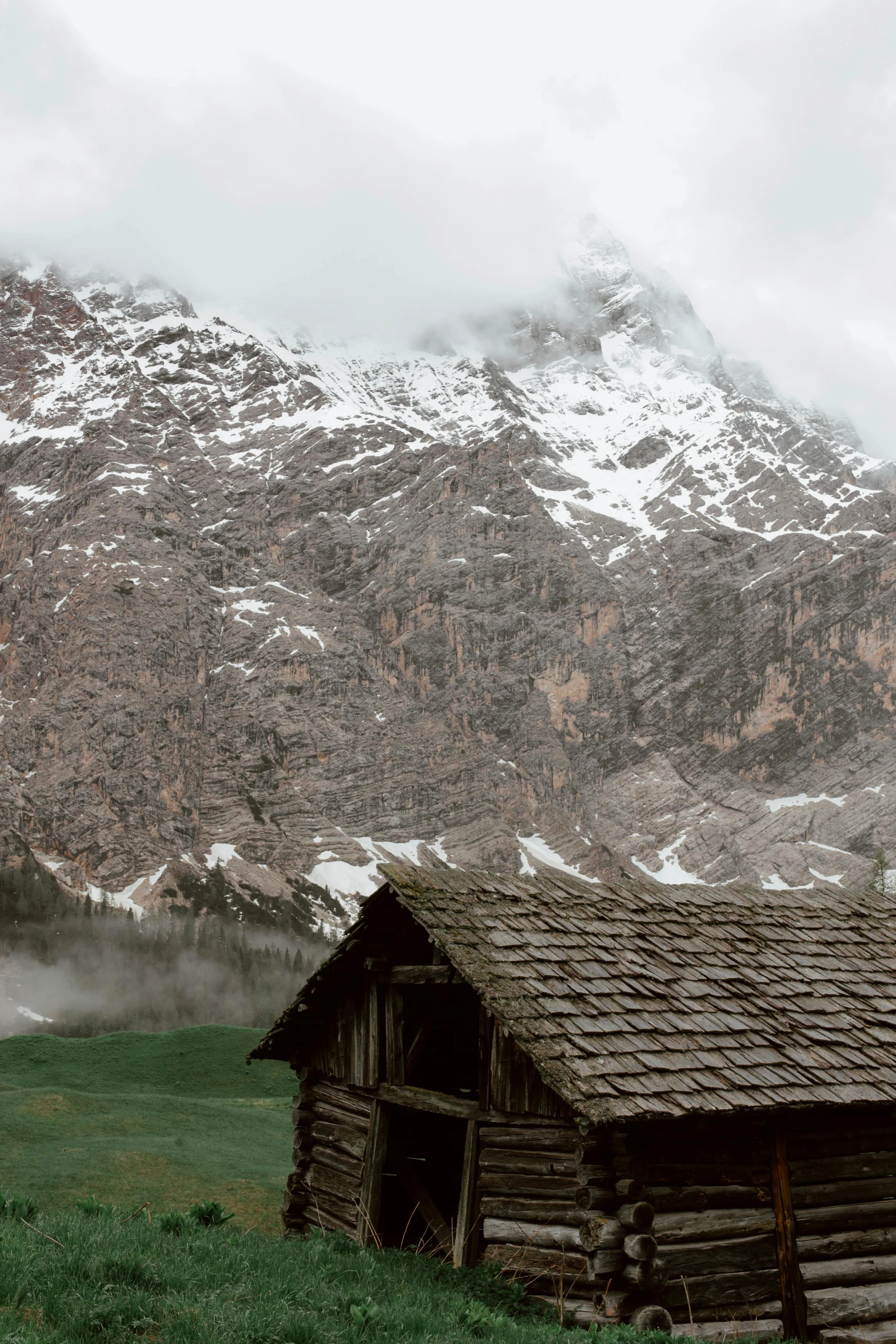 a cabin in a field with a mountain in the background, a matte painting, inspired by Peter Zumthor, pexels contest winner, renaissance, mist in valley, today\'s featured photograph 4k, panorama view, high elevation