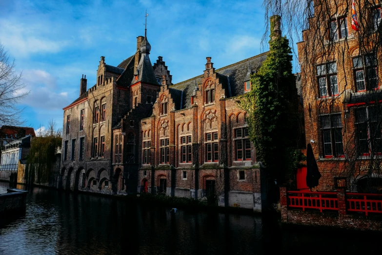 a large building next to a body of water, by Jan Tengnagel, pexels contest winner, renaissance, brick building, promo image, thumbnail, neo - gothic architecture