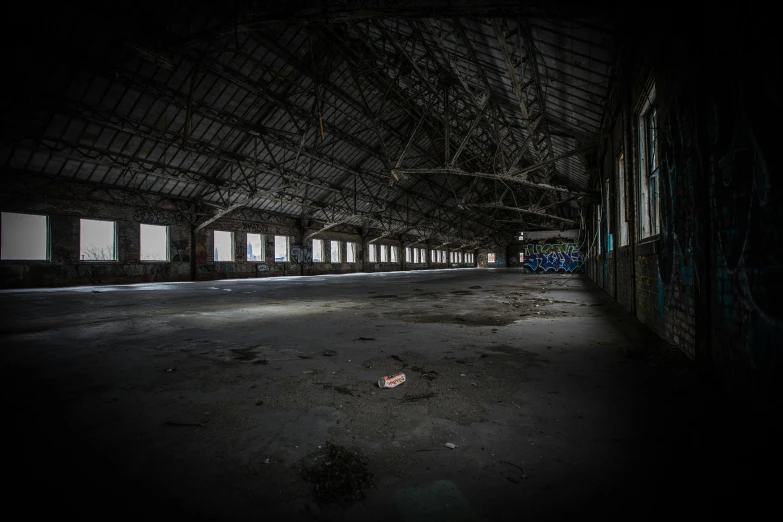 an empty building with graffiti all over it, pexels contest winner, corpses floor, dark hangar background, ((rust)), panoramic anamorphic