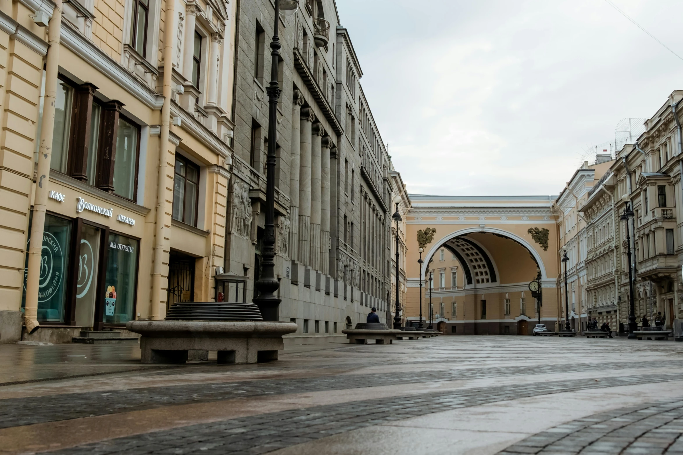 a man riding a skateboard down a street next to tall buildings, inspired by Illarion Pryanishnikov, pexels contest winner, neoclassicism, there are archways, paisley, benches, 000 — википедия