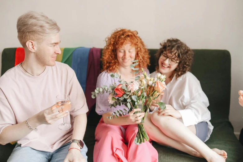 a group of people sitting on top of a green couch, holding flowers, ginger hair with freckles, giving gifts to people, profile image