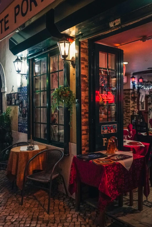 a couple of tables that are outside of a restaurant, a portrait, trending on unsplash, renaissance, dive bar with a karaoke machine, venetian red, profile image, cavernous interior wide shot