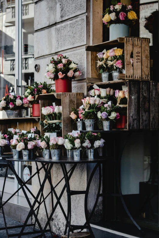 a woman standing in front of a flower shop, by Niko Henrichon, trending on unsplash, wooden crates, decorative roses, at a city street, overflowing