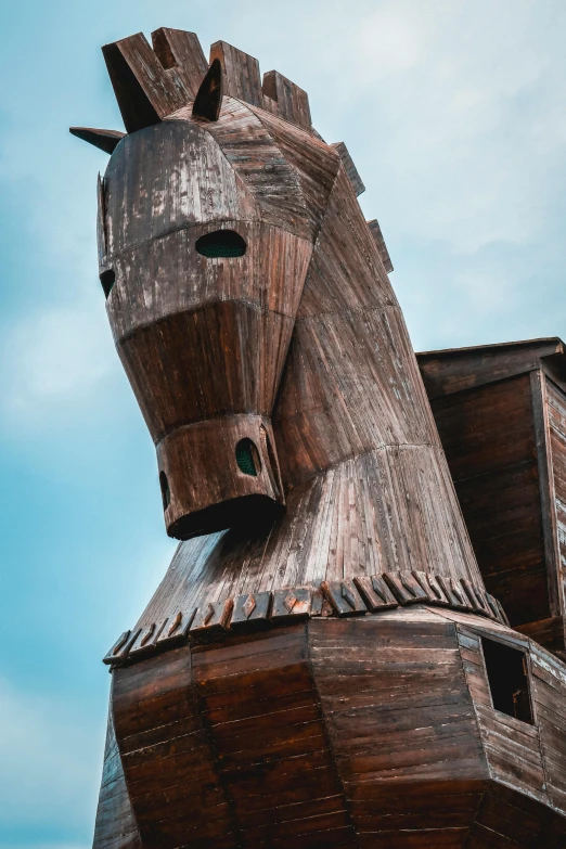 a wooden horse statue in front of a blue sky, by Daniel Lieske, trending on unsplash, arcane style viking battleship, high angle close up shot, gigantic tower, hestiasula head