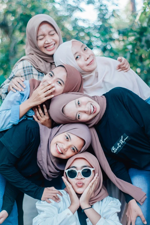 a group of women sitting on top of each other, inspired by JoWOnder, unsplash contest winner, hurufiyya, hijab, (winking), instagram post, sss