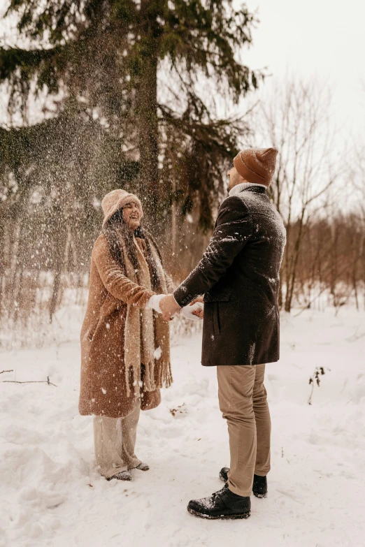 a man and woman shaking hands in the snow, pexels contest winner, brown clothes, happy couple, gif, 1 2 9 7