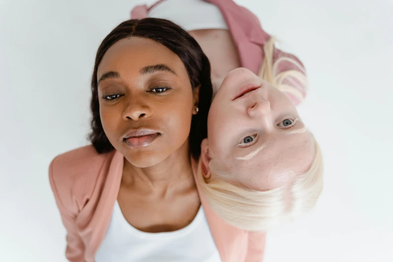 a couple of women standing next to each other, trending on pexels, hyperrealism, she is laying on her back, clear symmetrical face, diverse ages, colored