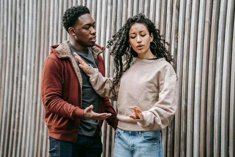 a man and a woman standing next to each other, trending on pexels, black teenage boy, arguing, woman holding another woman, disjointed style