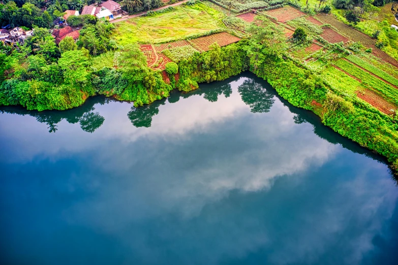 a river running through a lush green countryside, an album cover, by Daniel Lieske, pexels contest winner, hurufiyya, lake blue, airborne view, unmistakably kenyan, water mirrored water