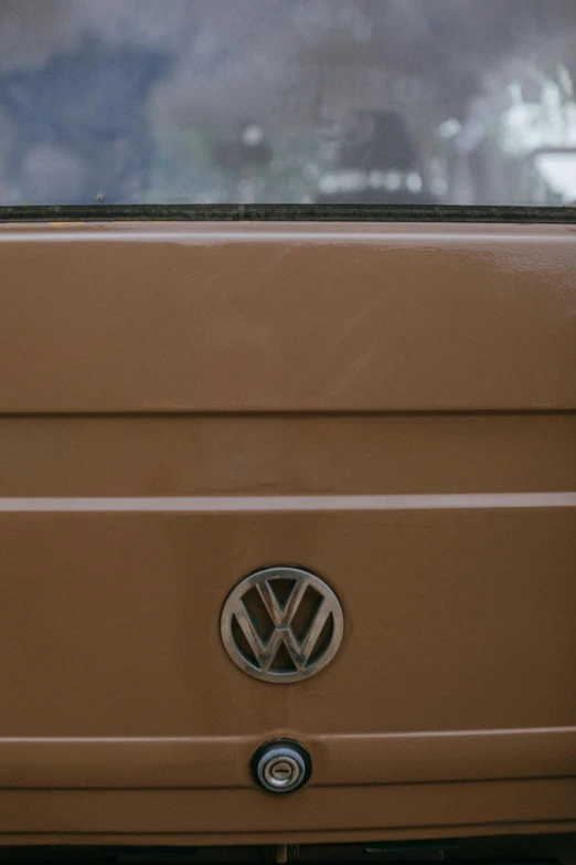 a brown vw bus parked in a parking lot, photographed for reuters, mechanical detail, square nose, rear-shot