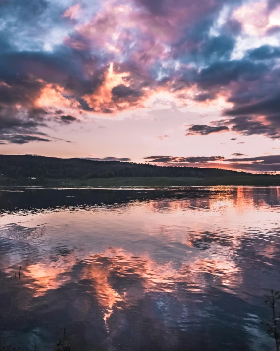a large body of water under a cloudy sky, a picture, by Roar Kjernstad, pexels contest winner, romanticism, pink golden hour, with instagram filters, iridescent reflections, portrait photo
