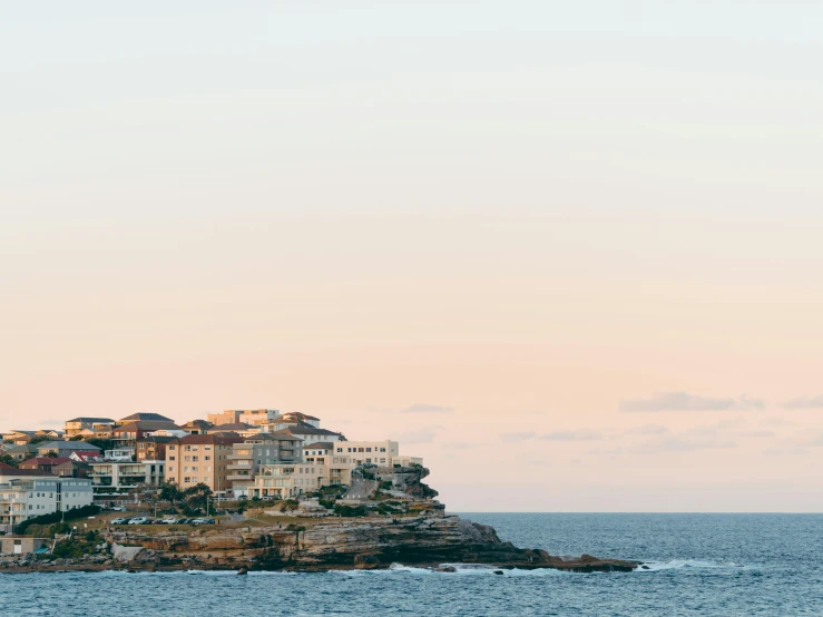 a large body of water with a bunch of buildings on top of it, pexels contest winner, minimalism, manly, coastal cliffs, soft glow, smug