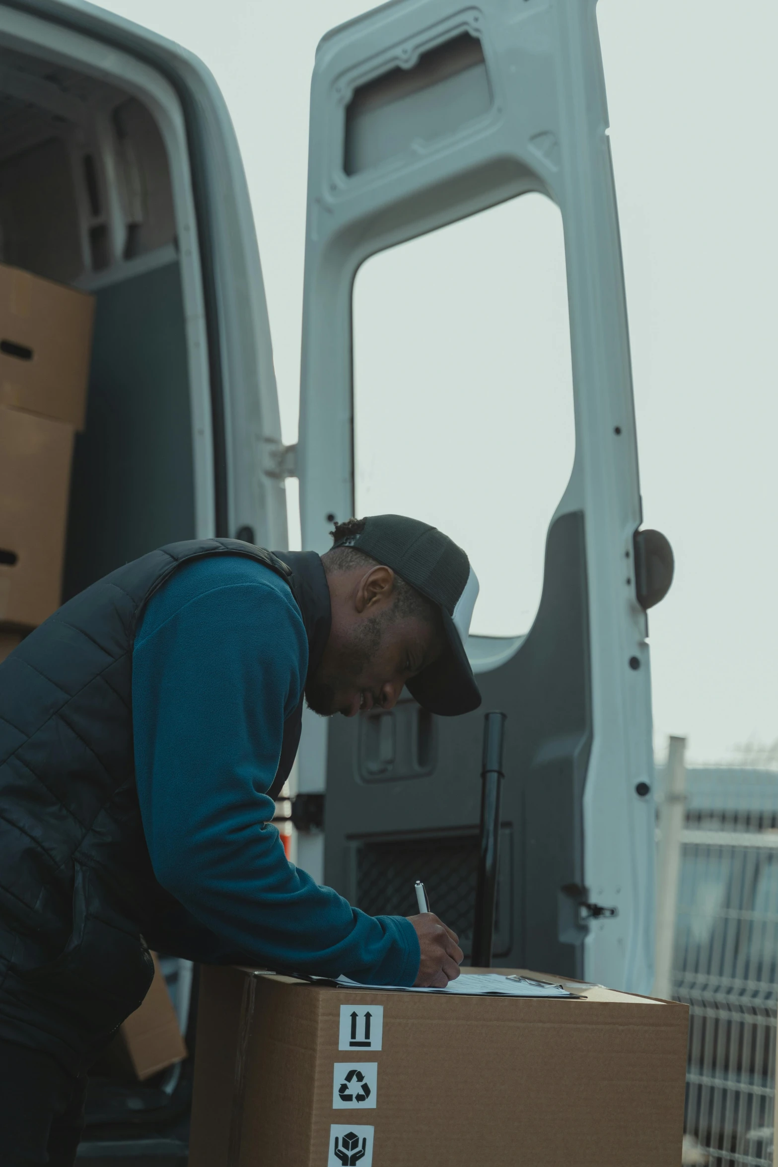 a man that is standing in front of a van, filling the frame, working, uploaded, black man