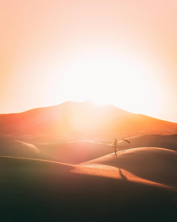 a person walking in the desert at sunset, unsplash contest winner, bathing in light, majestic dunes, on top of a hill, low quality photo