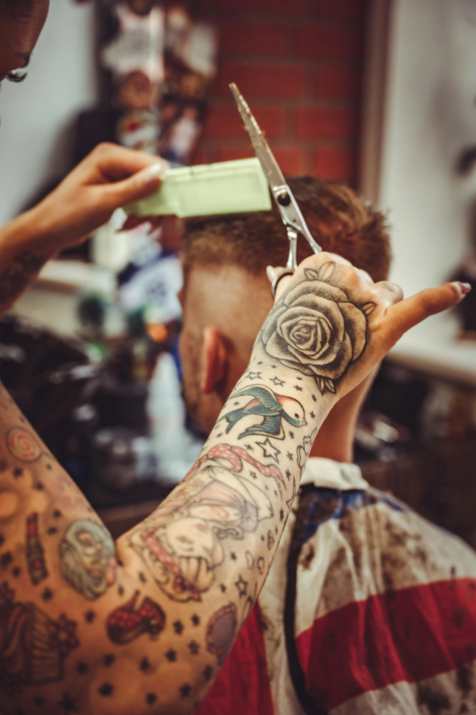 a man getting his hair cut at a barber shop, a tattoo, trending on pexels, process art, body covered in floral tattoos, hand holding a knife, rose in hair, vintage color