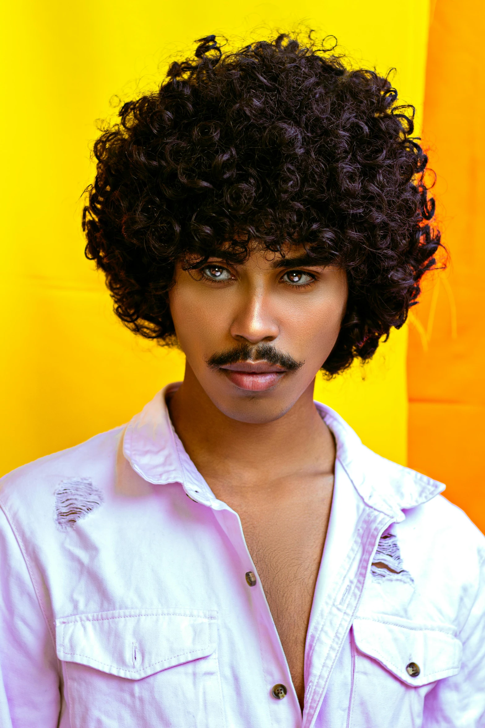 a man with a mustache standing in front of a yellow wall, an album cover, inspired by Tom Bonson, trending on pexels, funk art, imaan hammam, ru paul\'s drag race, handsome prince of persia, curly bangs